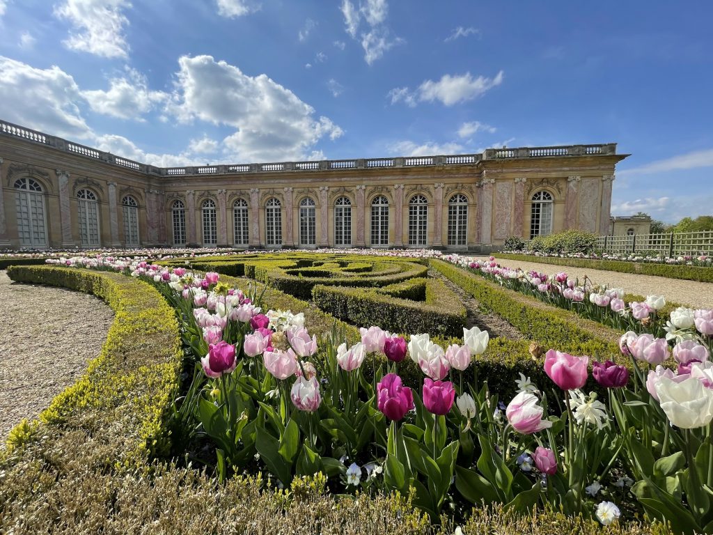 Grand Trianon at Versailles, featuring its distinctive pink marble façade and formal French gardens.