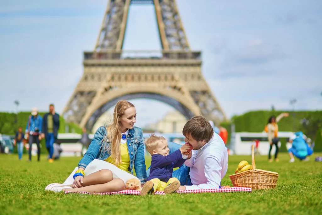 A Parisian family enjoying a delicious picnic in front of the Eiffel Tower.