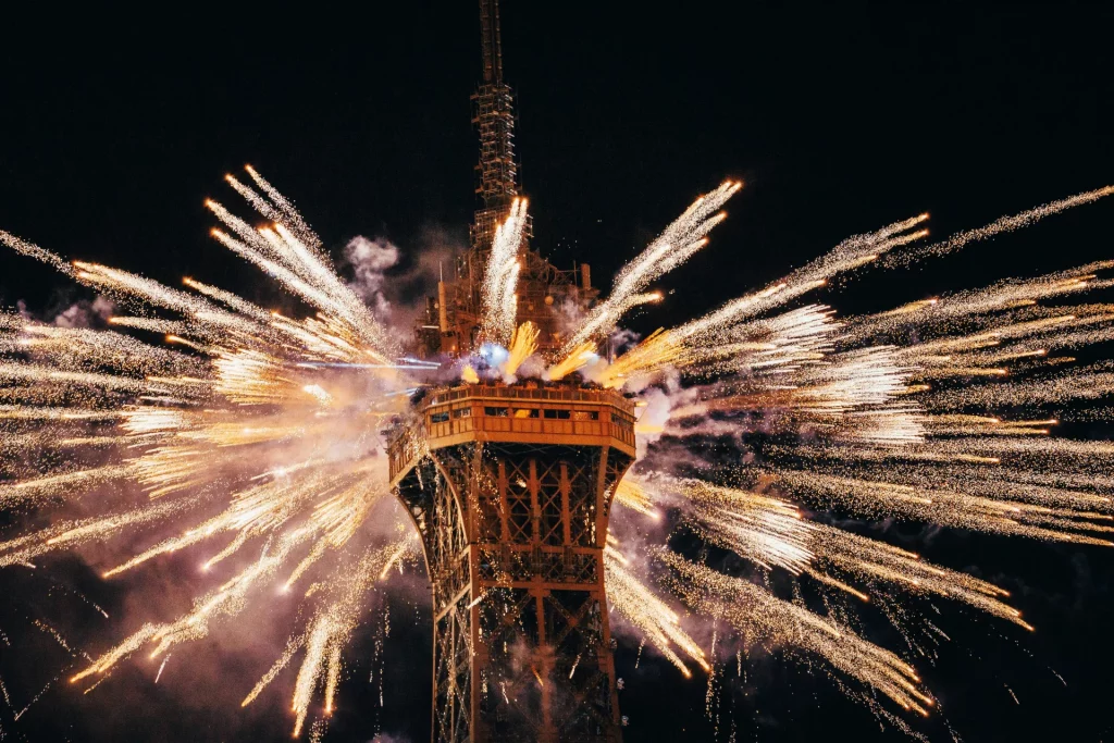 Fireworks setting off on top of the Eiffel Tower in Paris.