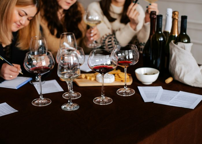 Women enjoying a Paris wine tasting class with a sommelier, sampling French wines in an elegant setting.