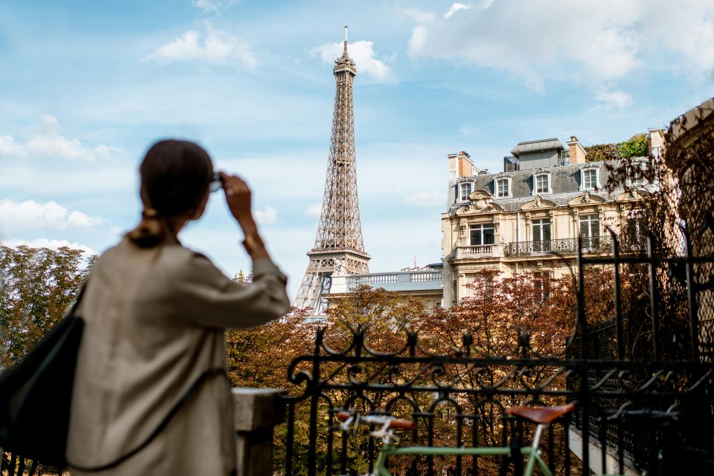 The Eiffel Tower View in Paris Autumn. With a women gazing at it. Cafe Carette