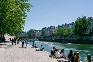 Parisians soaking in the sunshine on the Seine river banks during warm weather.