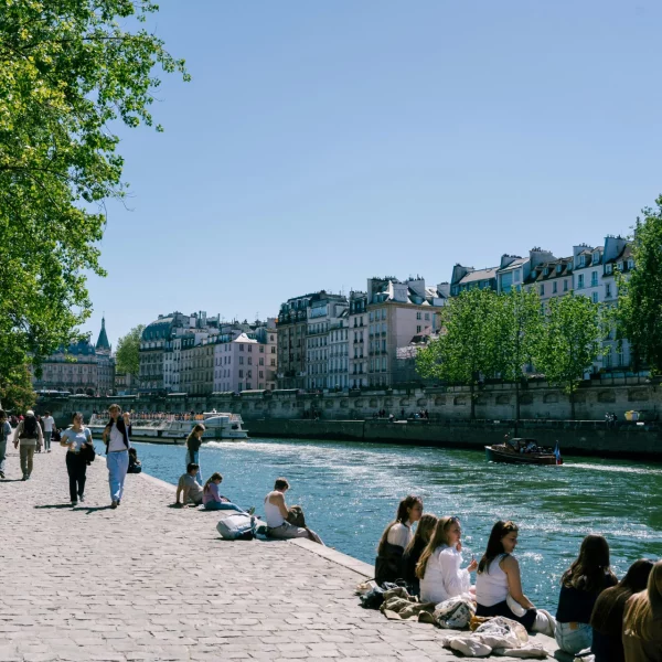 Parisians soaking in the sunshine on the Seine river banks during warm weather.
