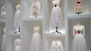 The Dior Gallery in Paris museum with display of Dior's white dresses with red details.My private paris Fashion Tour Paris