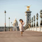 sunhat-woman-walking-in-paris Woman with sunhat walking on a brigde in Paris.