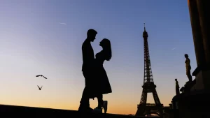 Silhouette of a couple hugging in front of the Eiffel Tower.