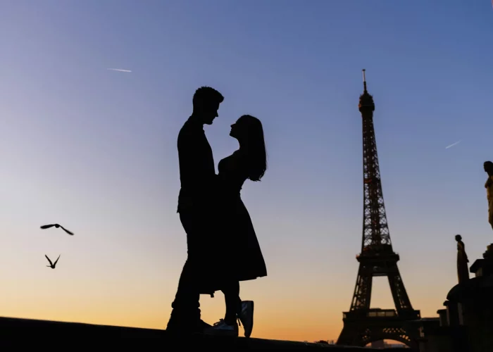 Silhouette of a couple hugging in front of the Eiffel Tower.