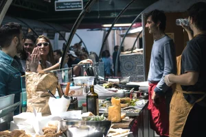Food vendors serving customers at the Marché des Enfants Rouges, Paris.